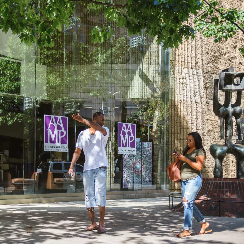 Two patrons walk outside of the African American Museum of Philadelphia