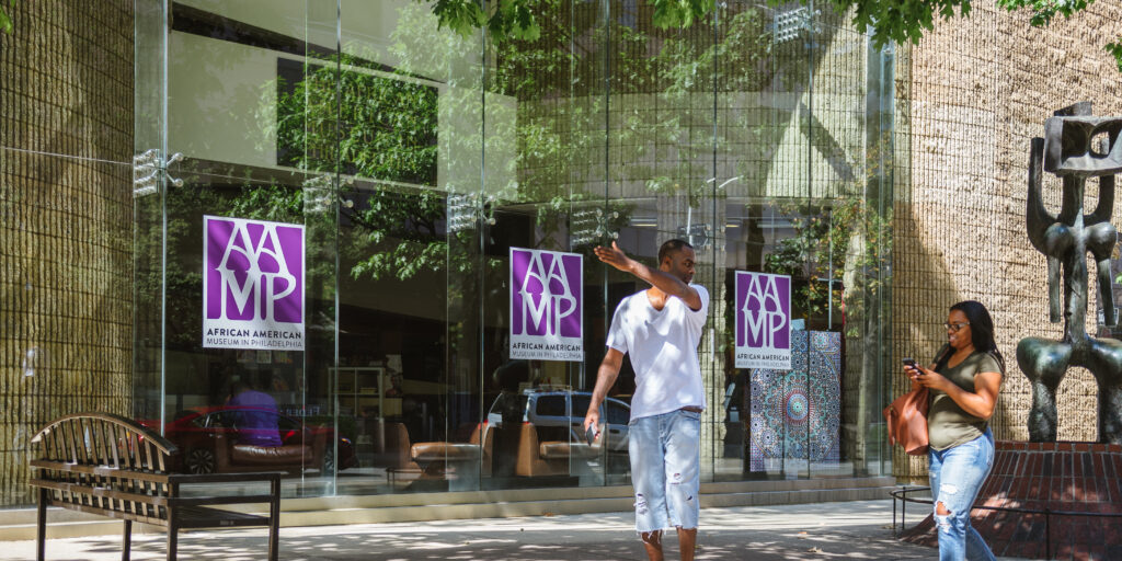 Two patrons walk outside of the African American Museum of Philadelphia