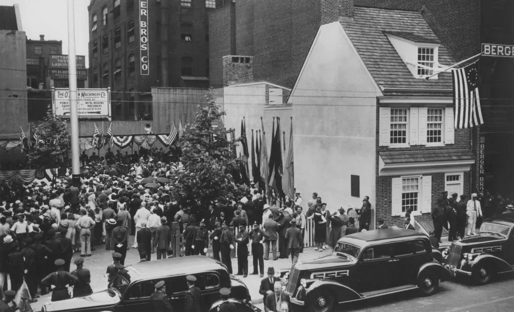 People gather in the Betsy Ross House courtyard during a flag day celebration, circa 1937.