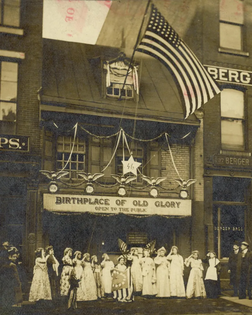 An archival photo showing a group gathered outside of the Betsy Ross House in the early 20th century