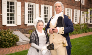 History Makers portraying George and Martha Washington pose outside of a colonial building