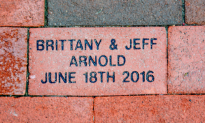 A personalized commemorative brick in Franklin Square that reads "Brittany & Jeff Arnold, June 18th 2016"