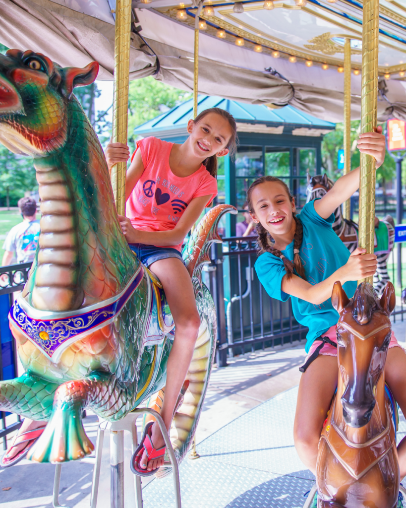 Two young riders enjoying a ride on the Parx Liberty Carousel in Franklin Square