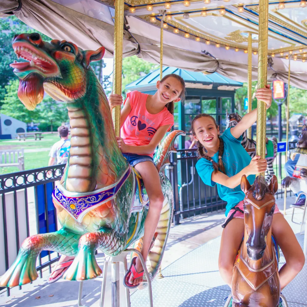 Two young riders enjoying a ride on the Parx Liberty Carousel in Franklin Square