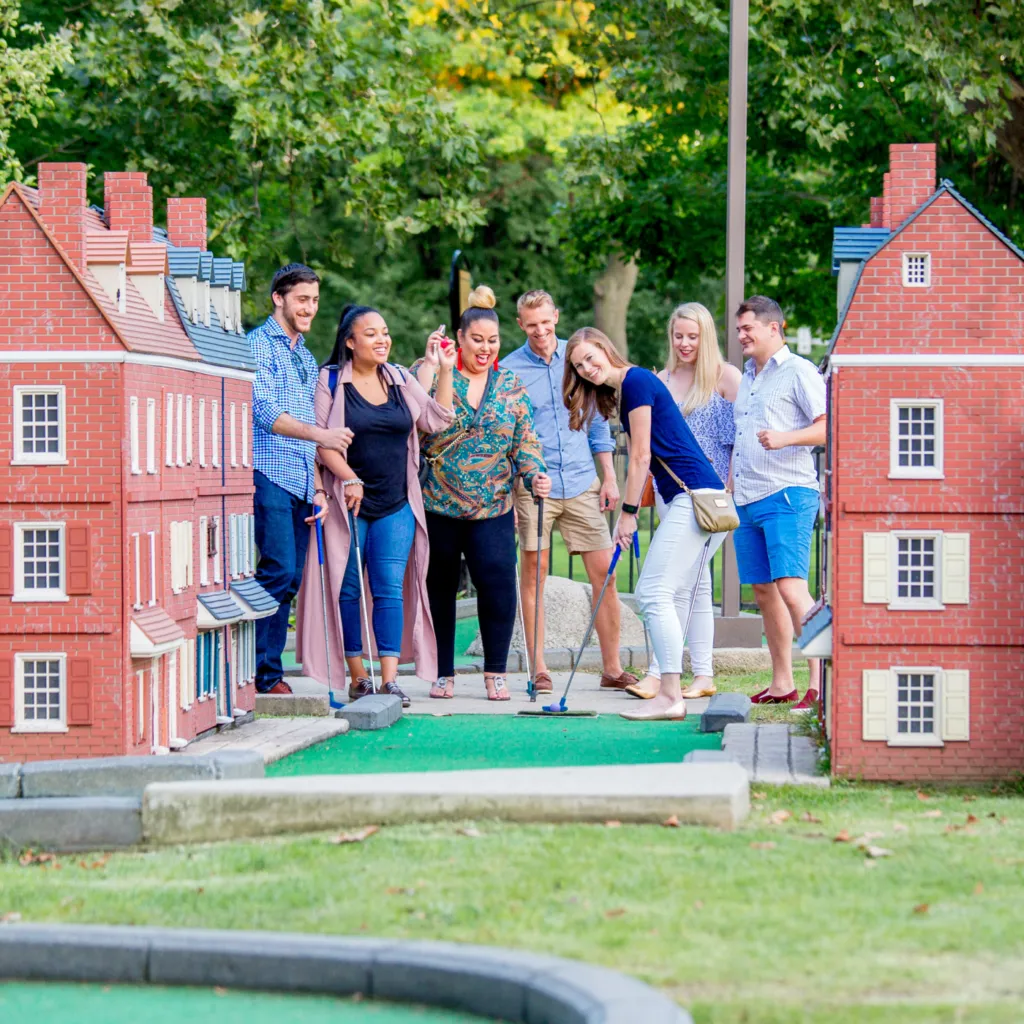 A group of young adults puts on a hole of Philly Mini Golf in Franklin Square