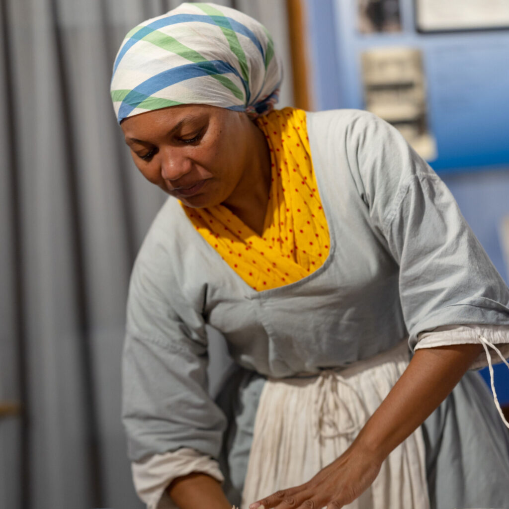 History Maker portraying Margaret Woodby rolls dough in the kitchen
