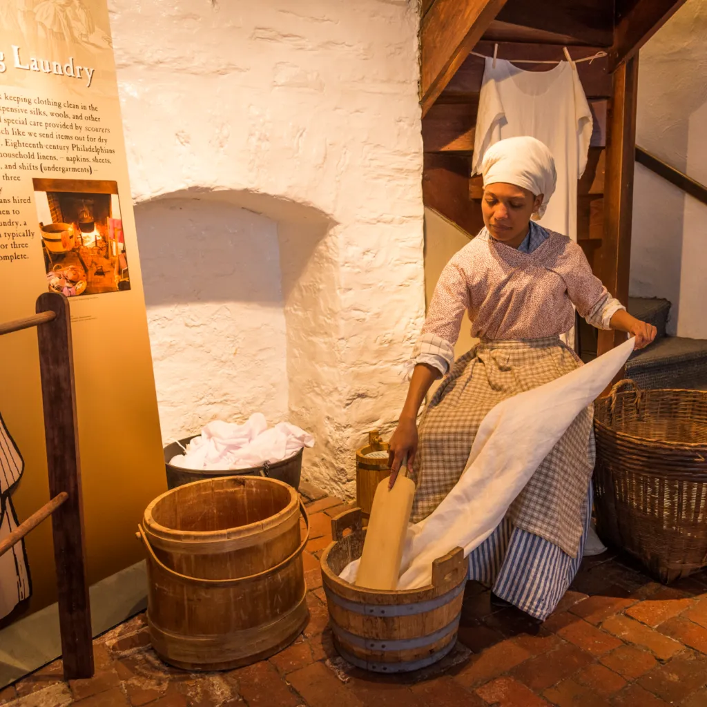 A History Maker in colonial costume demonstrates the process for doing laundry in the Betsy Ross House