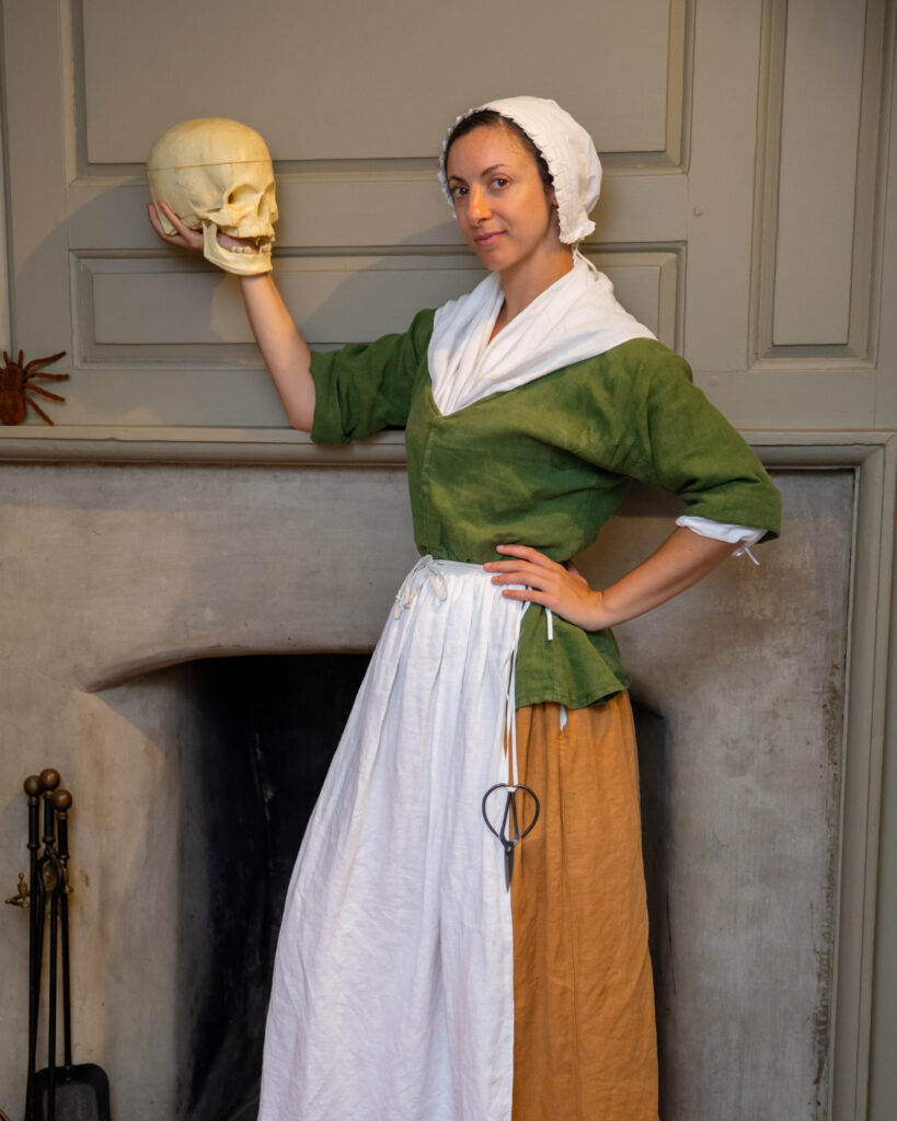 Photo of a Betsy Ross actress holding a fake human skull.