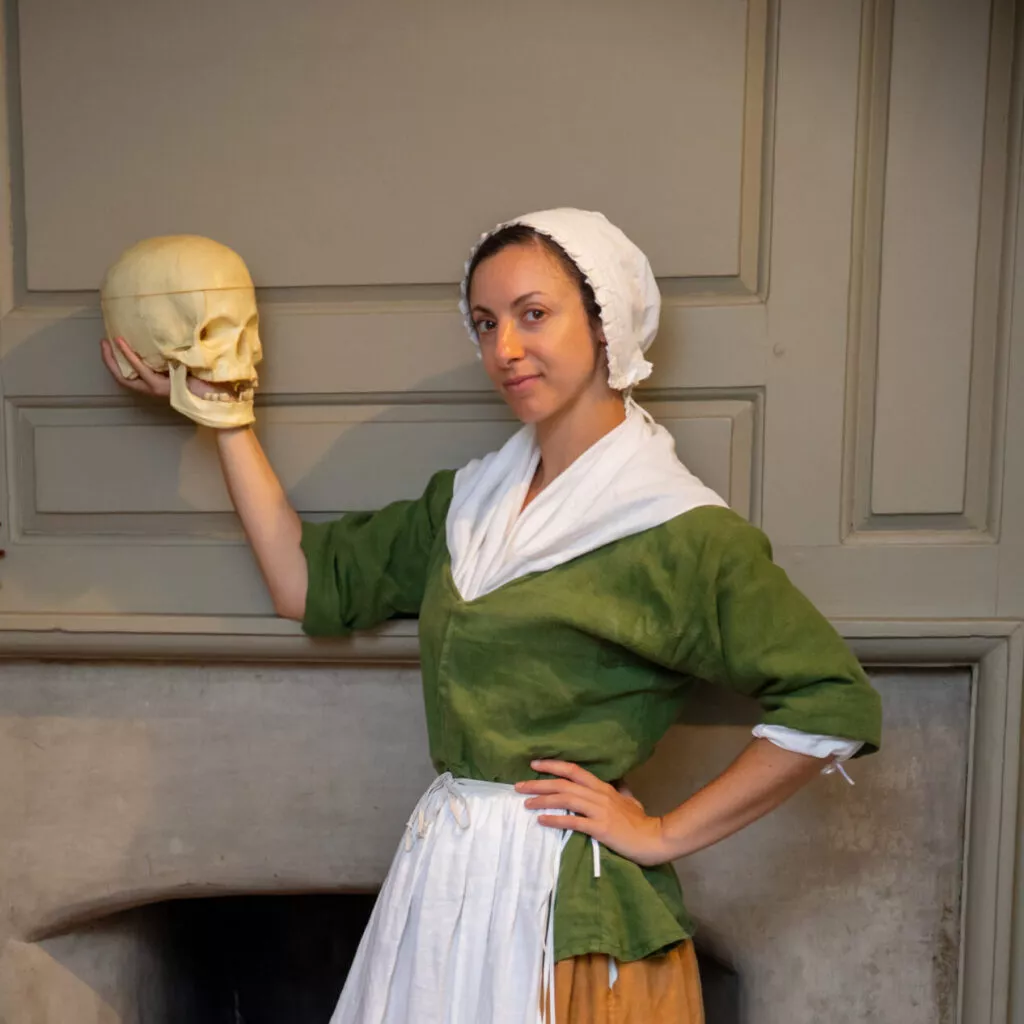 Photo of a Betsy Ross actress holding a fake human skull.