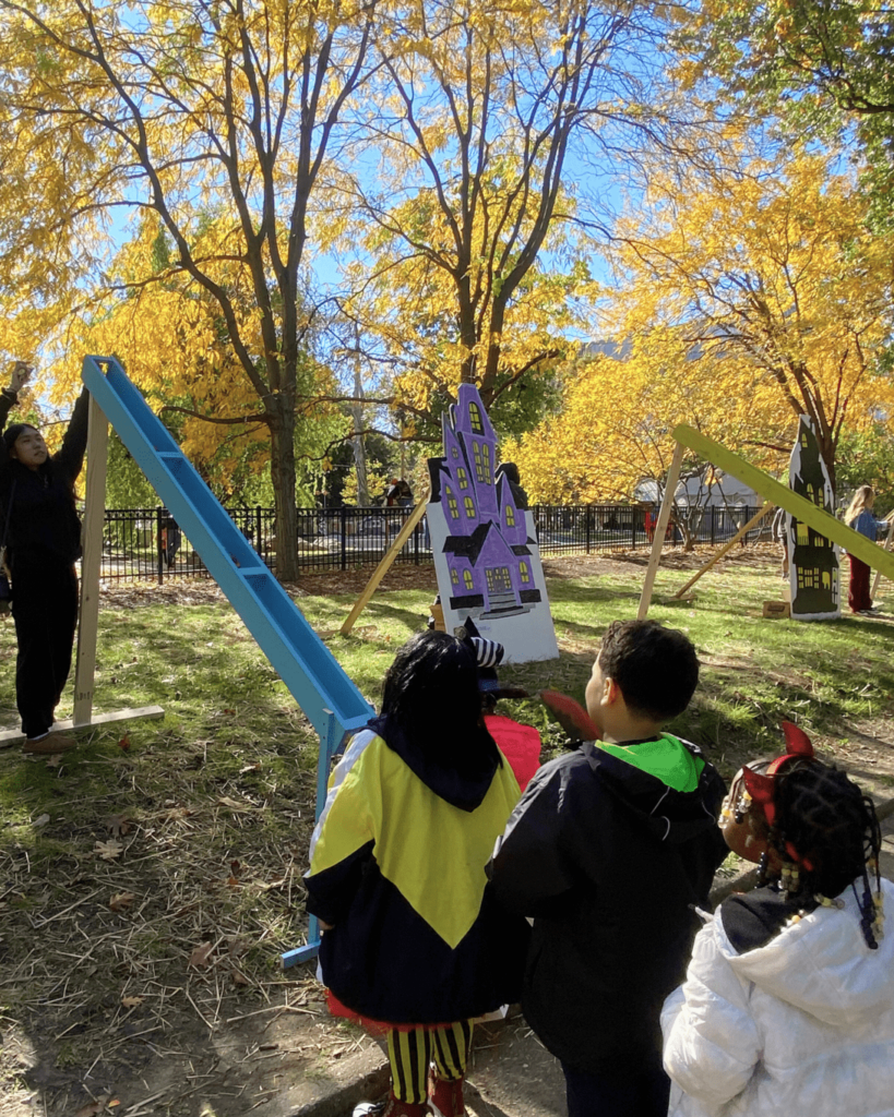 Photo of children waiting for their candy to come down the chute at Trick-or-Treat Street in Franklin Square